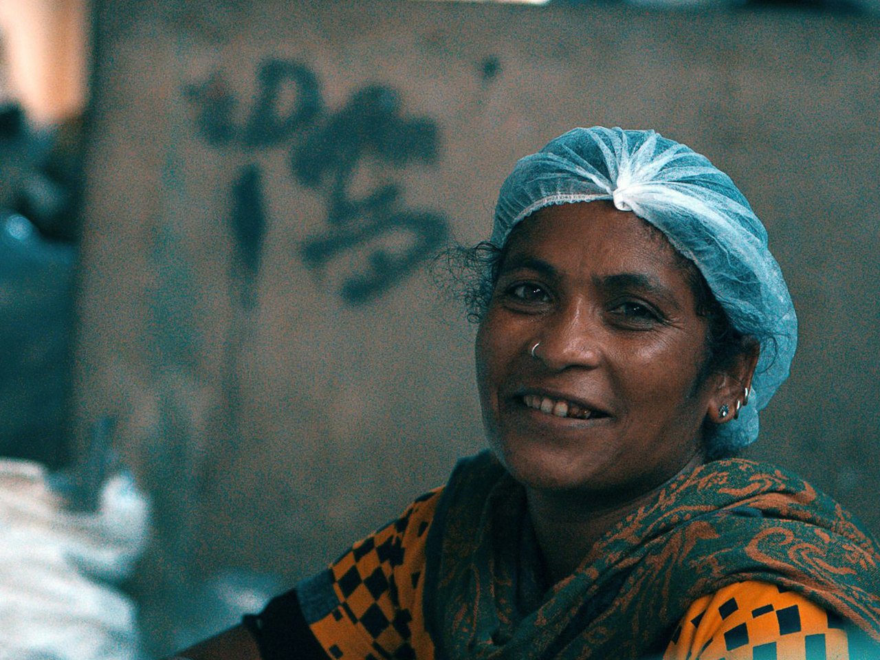 Frau in Recycling-Werk schaut in die Kamera